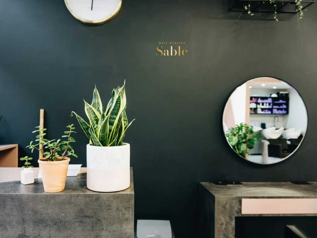 Cut vinyl lettering template CV-16 for a nail salon: Sable, gold Bodoni on a dark green wall