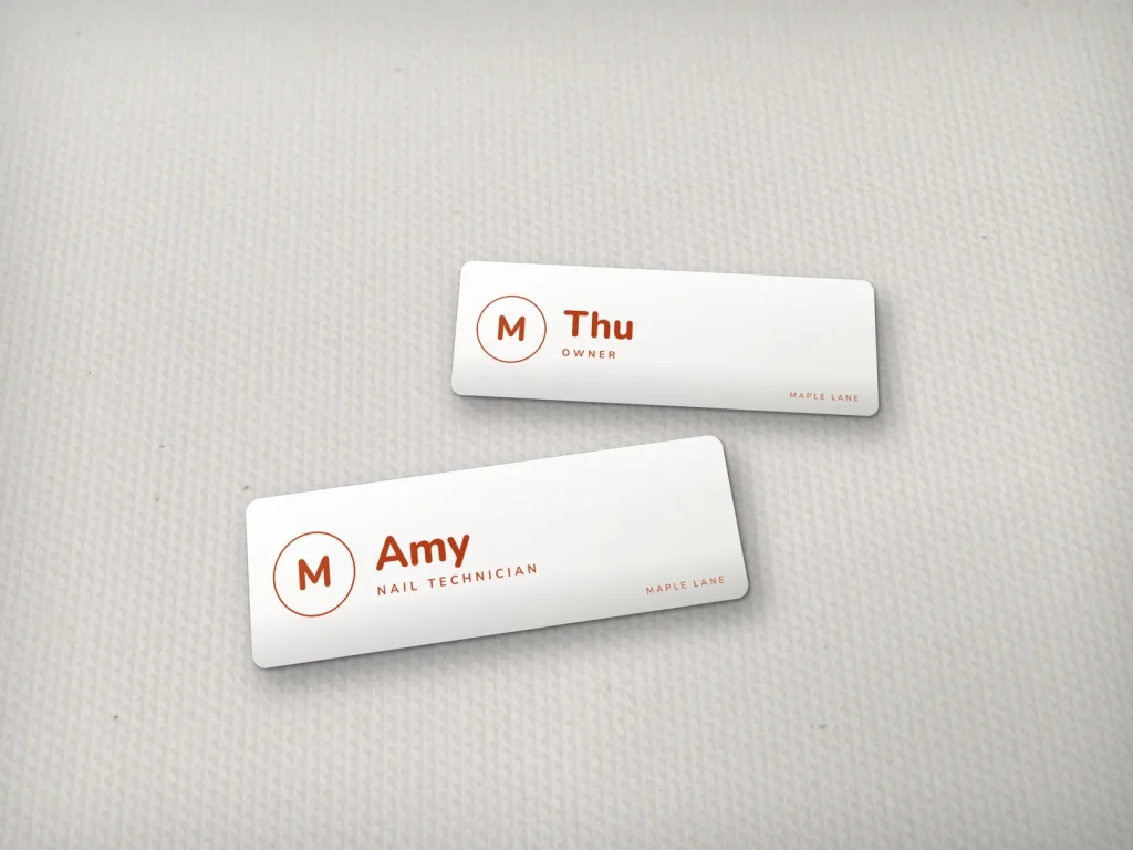 Mẫu name tag NT-11 cho tiệm nail: Maple Lane, nền trắng chữ đỏ cam